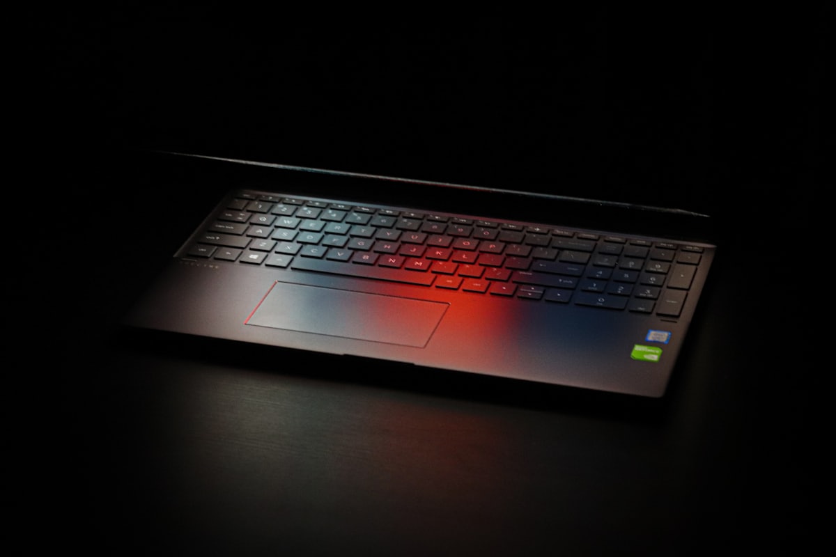 A laptop glowing with red light in a dark room